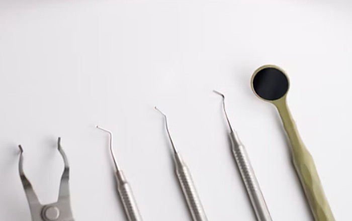 Espejo e instrumental de odontología sobre superficie blanca